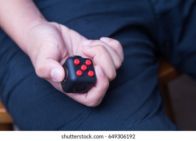 Person hand enjoy, play, press, relieve with the fidget cube