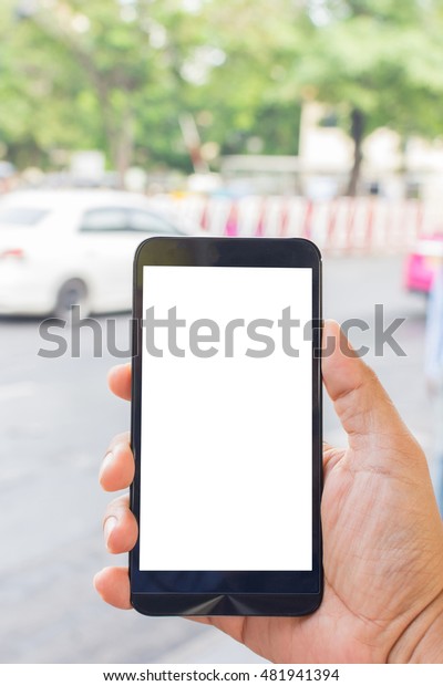 Person hand holding smartphone or mobile phone with\
white screen using on\
road