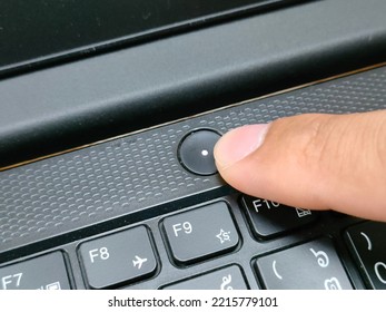 Person Hand Push Power Button On Laptop