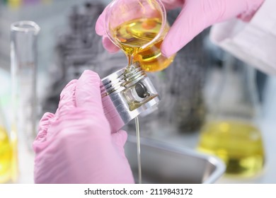 Person Hand In Rubber Pink Gloves Holding Car Part And Pours Lubricating Oil On Top