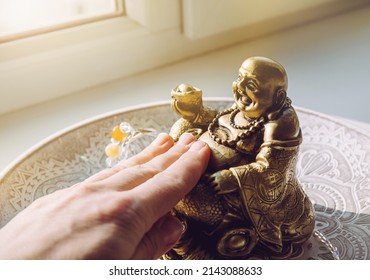 Person Hand Rubbing Small Golden Laughing Buddha Figurine Tummy. It Believed To Bring Happiness, Good Fortune And Wealth. Buddai Monk.