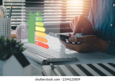 Person hand using laptop computer with house icon energy efficiency scale image on office desk, Concept of ecological and bio energetic house. Energy class. - Shutterstock ID 2194125859