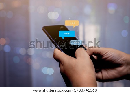 Person hand using smartphone typing, chatting conversation in chat bubble pop-up. Social media maketing concept.