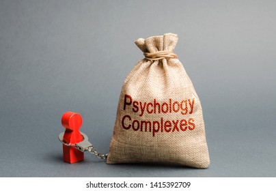 A person is handcuffed with a bag labeled psychological complexes. Feeling of inferiority and low self-esteem, low social skills, sociopathy and lack of communication. Phobias. Psychological help - Shutterstock ID 1415392709