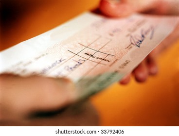 Person Handing Over Check In Financial Transaction.