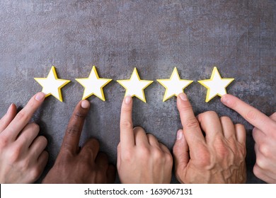 Person Hands Aligning Five Star Rating Icons. High Angle View