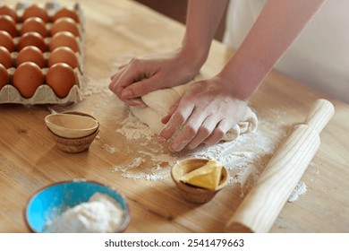 Person, hands and baking with dough, eggs or flour for dessert, pastry or recipe on table at home. Closeup, chef or baker with kneading for meal prep, mixing ingredients or cooking trial in kitchen - Powered by Shutterstock