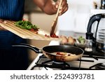 Person, hands and frying pan for meal in home, stove closeup and eggs for protein or nutrition. Breakfast, kitchen and organic ingredients for food preparation, healthy and cooking with vegetables