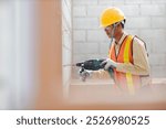 person hands hold hammer drill. Builder worker with pneumatic hammer drill perforator equipment making hole in wall at construction site