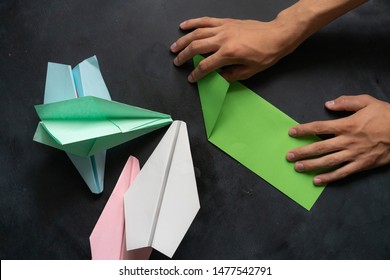 Person Hands Making A Origami Color Paper Plane