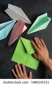 Person Hands Making A Origami Color Paper Plane