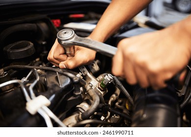 Person, hands and mechanic with spanner for fixing engine and motor maintenance in workshop. Industry, engineer and vehicle repairs with oil change in routine car checkup and service in garage - Powered by Shutterstock