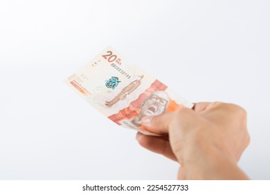 a person hands over a twenty thousand colombian peso bill