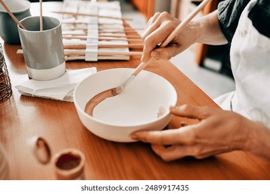 Person, hands and painting in pottery studio with creative pattern, art design and small business. Closeup, artist and color process for ceramic bowl with sculpture product, manufacturing and startup - Powered by Shutterstock