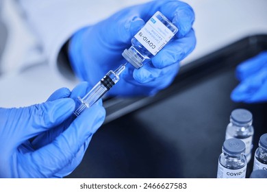 Person, hands and vaccine bottle with needle for treatment or illness control for virus, disease and liquid vial. Medical worker, booster and shot for immunization, prevention and cure for covid 19. - Powered by Shutterstock