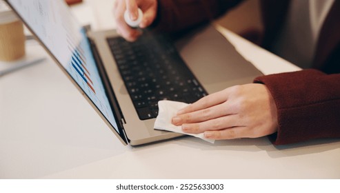 Person, hands or wipe with laptop for hygiene, sanitize or cleaning bacteria and dirt on office desk. Closeup, employee or hygienist with cloth on technology or computer for disinfection at workplace - Powered by Shutterstock