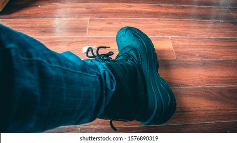 Person Having The Snow Black Snow Shoes On The Wooden Floor.