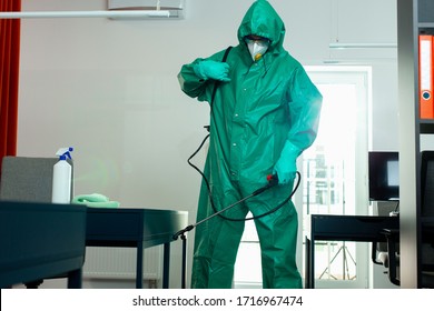 Person In Hazmat Sanitizing The Room By Disinfecting Fogging. Portable Disinfectant Tank In His Hands