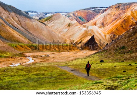 Person hiking at Landmannalaugar colorful mountains in Iceland