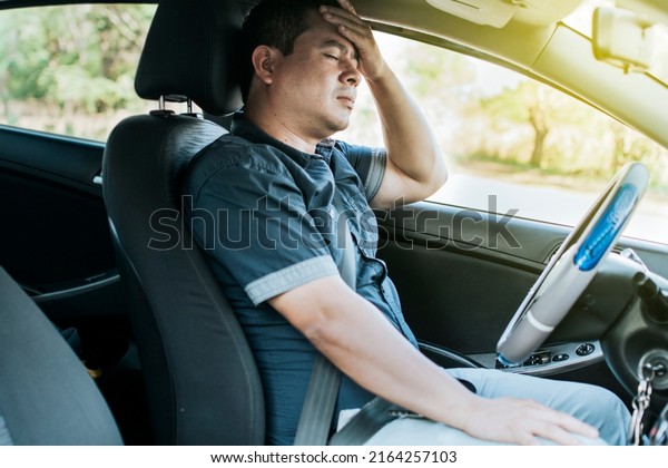 A person in his car with a headache, Concept of\
a man in his car with a headache, A car driver with a headache, A\
driver with stress and\
migraine