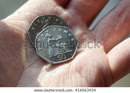 Person Holding 2 Fifty Pence Coins