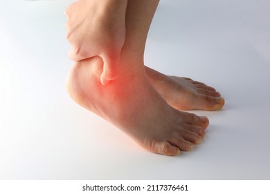 A person holding ankle on Achilles tendon, suffering with pain in red spot area. Sprain ligament or Achilles tendonitis symptoms. Image with red highlights on hurting area, Health care concept