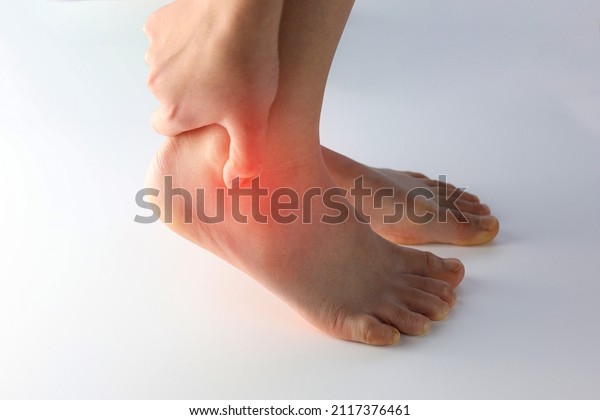 A person holding ankle on Achilles tendon,\
suffering with pain in red spot area. Sprain ligament or Achilles\
tendonitis symptoms. Image with red highlights on hurting area,\
Health care concept