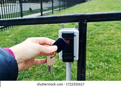 A Person Holding Attaching Key Fob To Open Door. Closeup Of Human Hand With Magnetic Key Fob For Allowing Access. Security System Mechanism Technology.