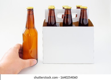 A Person Holding A Beer With A Six Pack Of A Brown Beer Bottles Isolated On White Background