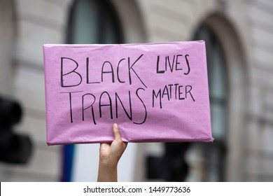 A Person Holding A Black Trans Lives Matter Banner At A Gay Pride Event