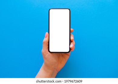 Person Holding Blank Mobile Phone In Hand On Blue Background