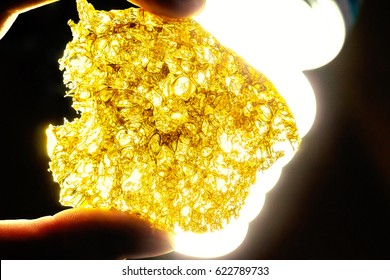 Person Holding Cannabis Butane Hash Shatter -- Glowing back lit fluorescent