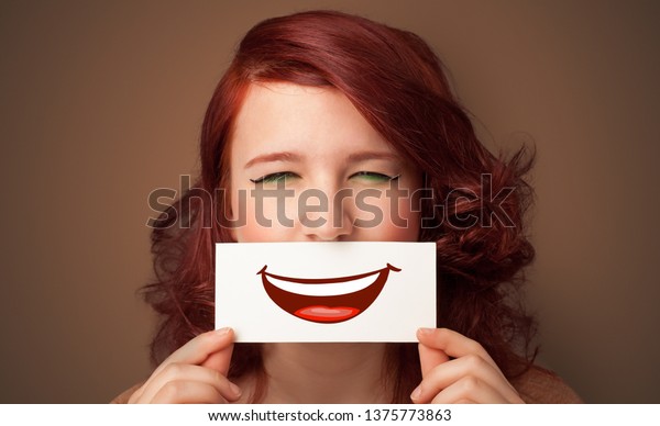 Person holding card in front of his mouth with\
ironic smile