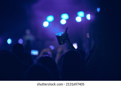 Person holding cold beer plastic cup on a music festival.
