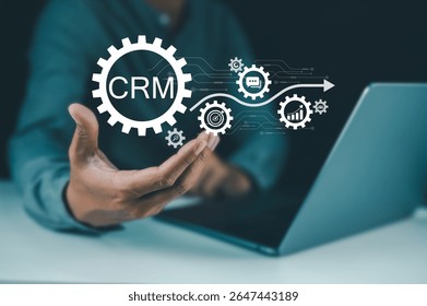 A person holding a digital interface with CRM and gear icons representing customer relationship management and automation.