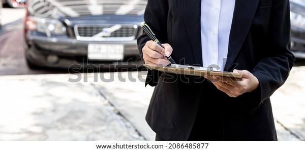 A\
person holding a file, a female employee of a car rental company is\
about to deliver the car to a customer who has signed a rental\
contract and paid the deposit. Car rental\
concept.