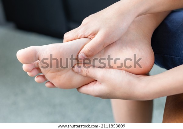A person holding forefoot with pain, Forefoot pain,\
metatarsalgia symptom, tenderness in the balls of metatarsal bones\
in human foot.