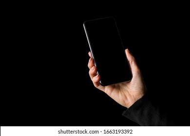 Person Holding In Hand Mobile Phone, Isolated On Black Background