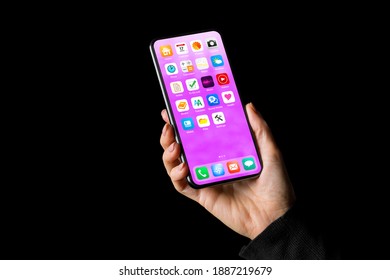 Person holding in hand mobile phone with app icons on home screen - Shutterstock ID 1887219679