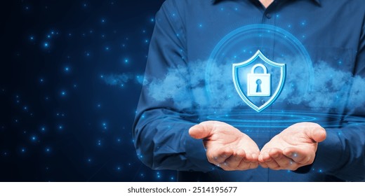 Person holding a holographic lock and shield icon, representing cybersecurity, on a blue background with digital elements. Concept of online protection - Powered by Shutterstock