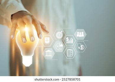 A person is holding a light bulb and the image is titled "The Light Bulb". The image is a representation of a light bulb and the idea of innovation and creativity - Powered by Shutterstock