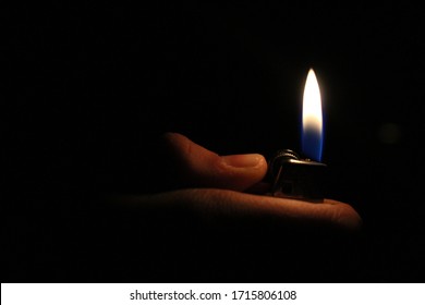 Person Holding A Lit Lighter At Night