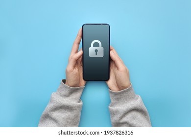 A Person Is Holding A Locked Phone. Trying To Find A Password To Log In To The System