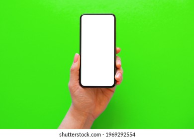 Person Holding Mobile Phone With Empty White Screen On Green Background