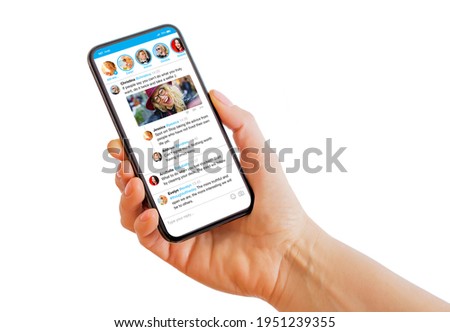 Person holding mobile phone in hand with sample social media microblogging app on the screen