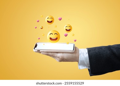 A person is holding a mobile phone with a smiley face on it. - Powered by Shutterstock