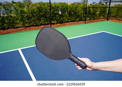 Person Holding Pickle Ball Paddle On Court.                      