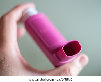 A Person Holding A Pink Asthma Inhaler