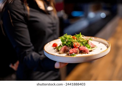 Person holding a plate of gourmet salad with seared tuna. The image captures the art of fine dining and beautifully presented dish - Powered by Shutterstock