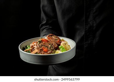 A person holding a plate with a perfectly grilled steak and colorful vegetables. The dark background enhances the contrast, making the food look even more appetizing and visually appealing. - Powered by Shutterstock